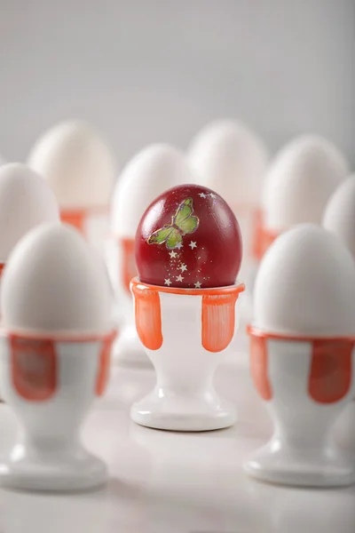 Κόκκινο αβγό με δεκάδες λευκό αυγά — Φωτογραφία Αρχείου