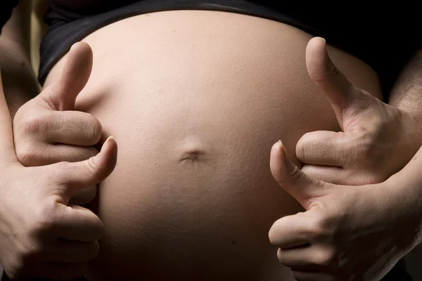 一个怀孕的女人抱着她的肚子里用两只手 — 图库照片