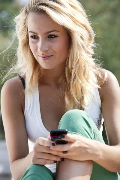 휴대 전화에서 메시지를 읽는 젊은 여성 스톡 사진