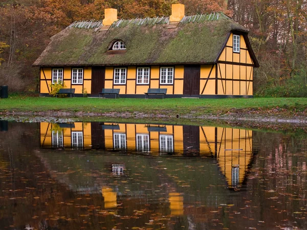 Maison à colombages jaune au lac — Photo