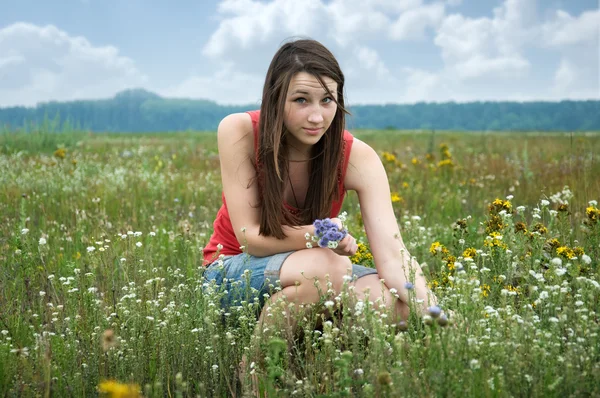 Girl with a bouquet of wildflowers — Stock Photo, Image