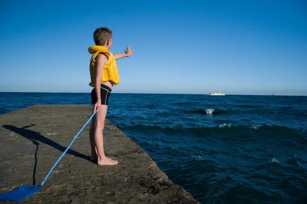 Boy on the pier waving — Stock Photo, Image