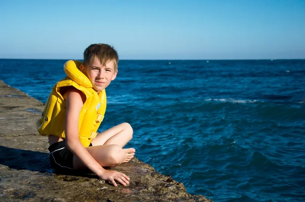 Menino em colete salva-vidas amarelo — Fotografia de Stock