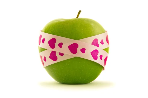 Green apple with pink gift ribbon — Stock Photo, Image