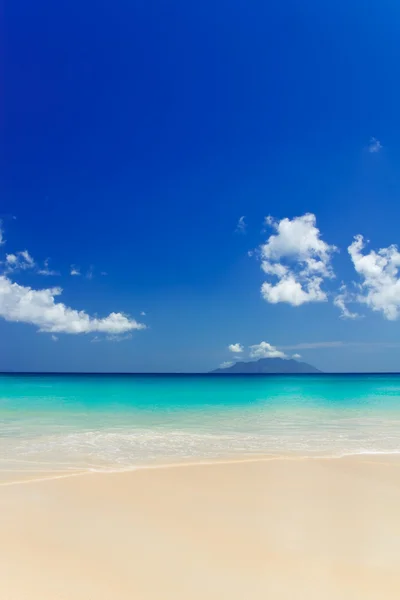 Praia de areia branca tropical e céu azul. — Fotografia de Stock