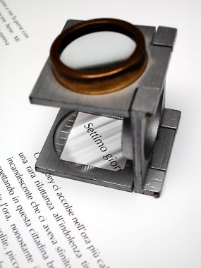 Macro of text and loupe on printed sheet clipart