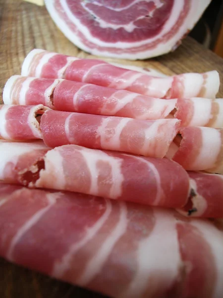 Närbild av skivor av rullen rå bacon — Stockfoto
