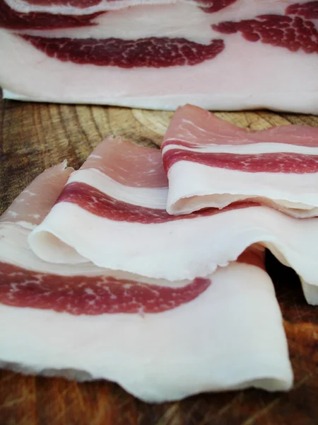 Closeup de um pedaço de bacon com fatias — Fotografia de Stock