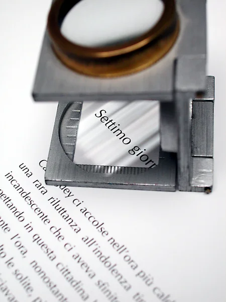 Makro teks dan loupe pada lembar yang dicetak — Stok Foto