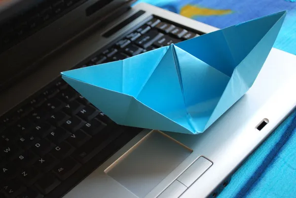 Barco de papel vela en el ordenador portátil —  Fotos de Stock