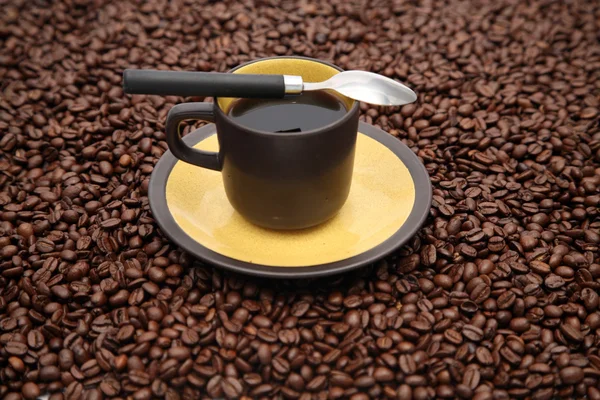 Kaffeetasse und Löffel auf die Bohnen — Stockfoto