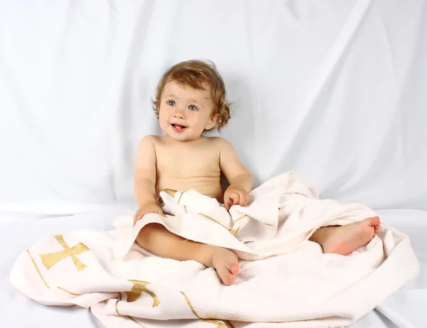 Smiling baby hidden in towel Stock Photo