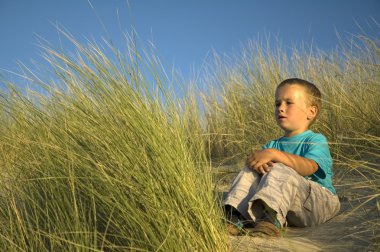 Boy Sitting In The Dunes