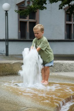 Boy Playing With Fountain clipart