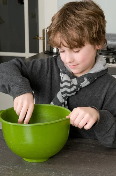 Мальчик делает тесто для тортов — стоковое фото