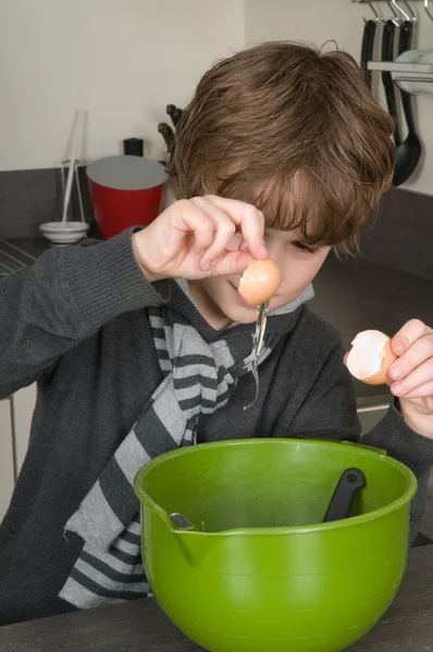Мальчик делает тесто для тортов — стоковое фото
