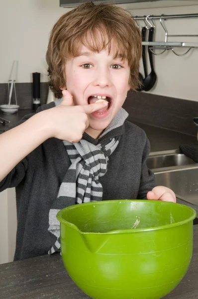 Мальчик ест тесто — стоковое фото