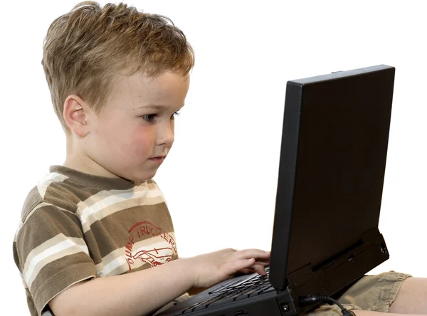 Bir dizüstü bilgisayar üzerinde çalışan bir çocuk — Stok fotoğraf