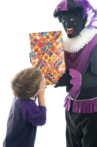 Zwarte Piet giver et barn sin gave - Stock-foto