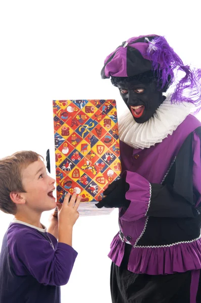 Zwarte Piet giver et barn sin gave - Stock-foto