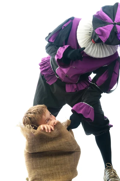 Zwarte Piet with a child in the bag, to take him to Spain... — Stock Photo, Image