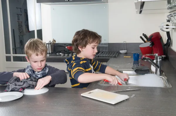 Due ragazzi che lavano i piatti — Foto Stock