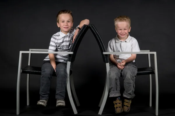 Dois irmãos em uma cadeira — Fotografia de Stock