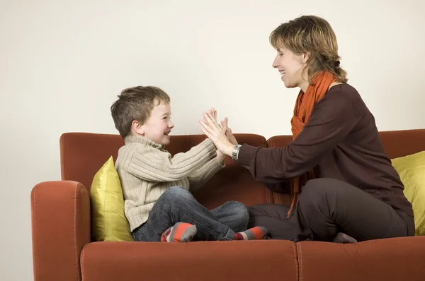 Mutter und Sohn spielen auf einer Couch — Stockfoto