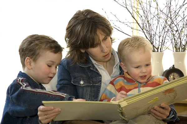 Mãe e dois filhos lendo um livro — Fotografia de Stock