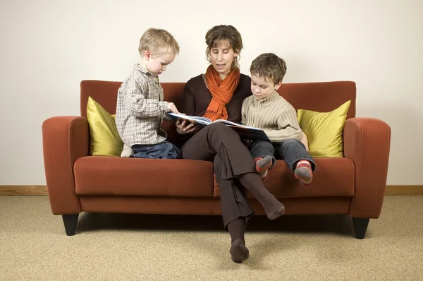 Mor och två söner läser en bok 4 — Stockfoto