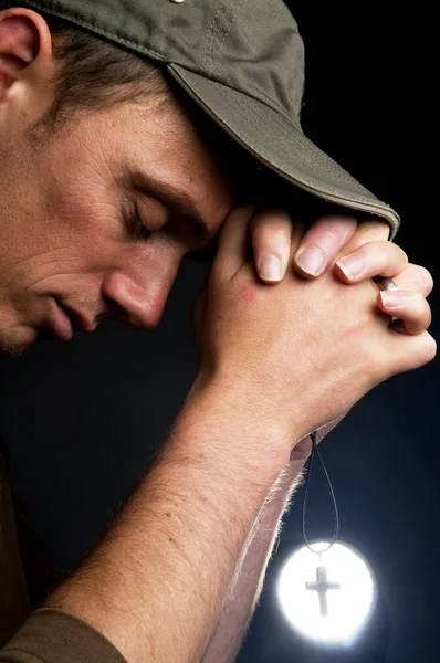 Homme priant tenant une croix — Photo