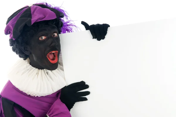Zwarte Piet looking at a white board, to put your text in. — Stock Photo, Image