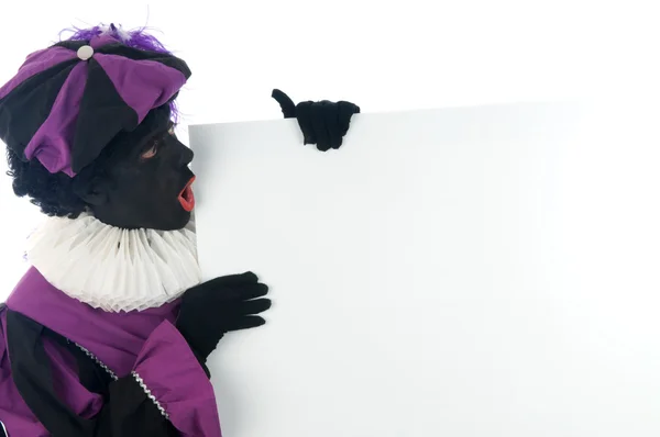 stock image Zwarte Piet looking at a white board, to put your text in.