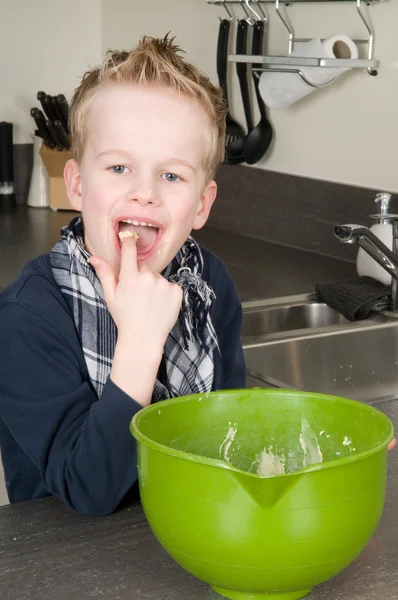 Junge isst Teig — Stockfoto