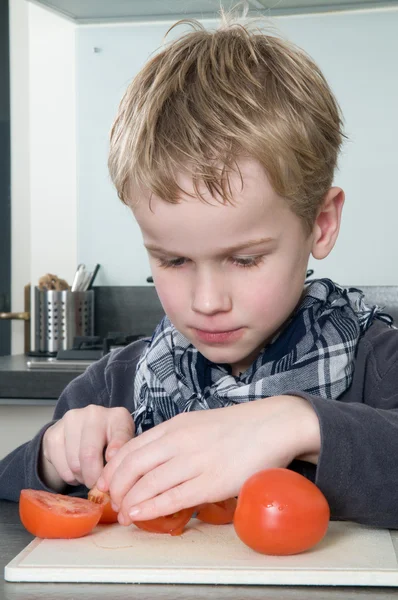 Boy cutting tomato — Stock Photo, Image