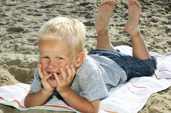Ragazzo sdraiato su una spiaggia — Foto Stock