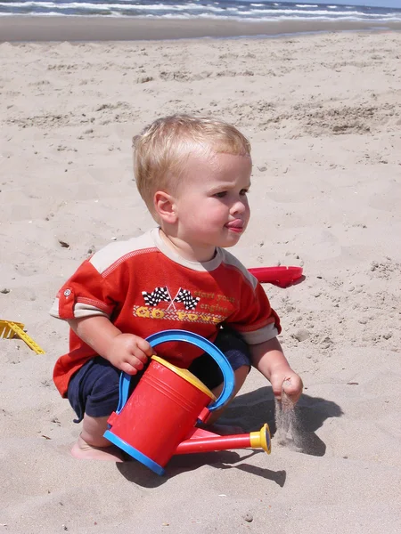 Küçük çocuk kumsalda oynuyor. — Stok fotoğraf