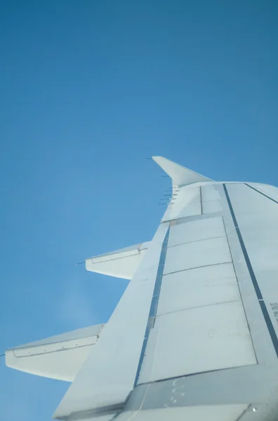 Vleugel van het vliegtuig tegen een blauwe hemel — Stockfoto
