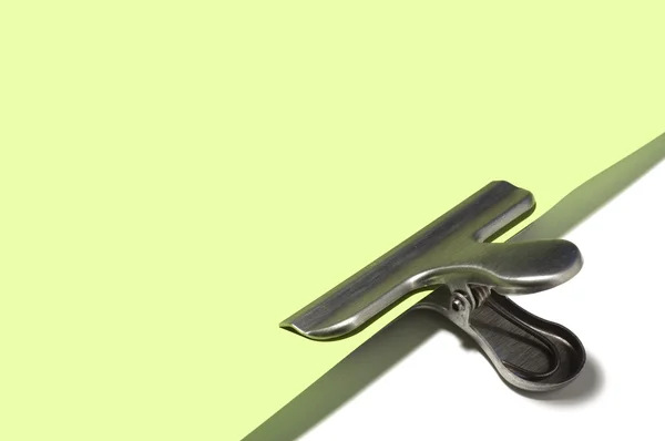 Metallic paperclip on green paper — Stock Photo, Image