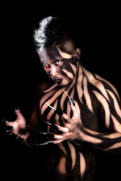 Man met zwart lichaam verf claws dragen op de vingers — Stockfoto