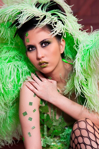 Vrouwelijke dragen groene veren outfit — Stockfoto
