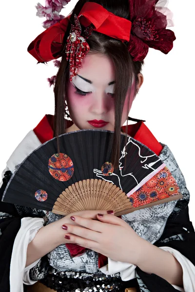 Bella donna asiatica che indossa un abito giapponese con un ventilatore pieghevole Immagine Stock