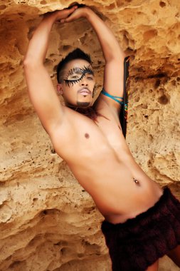 Tribal Male Posing Outside Against a Mountain Wall clipart