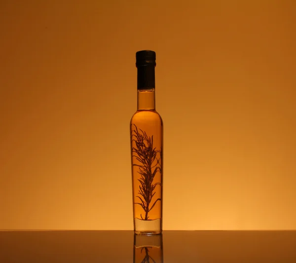 Бутылка оливкового масла, приправленная розмарином — стоковое фото