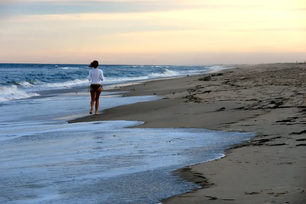 Młoda kobieta biegająca po plaży — Zdjęcie stockowe