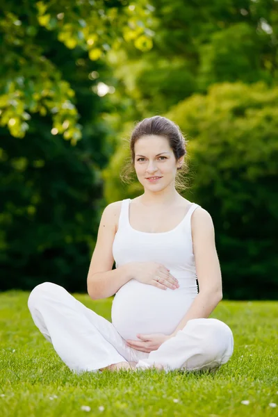 Красивая беременная женщина в парке — стоковое фото