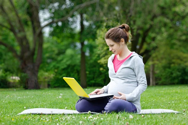 Donna incinta con computer portatile — Foto Stock