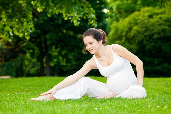 Беременная женщина отдыхает в парке — стоковое фото
