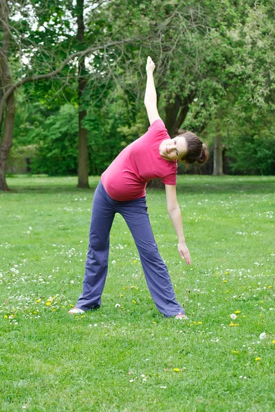 Mujer embarazada haciendo ejercicio en el parque —  Fotos de Stock