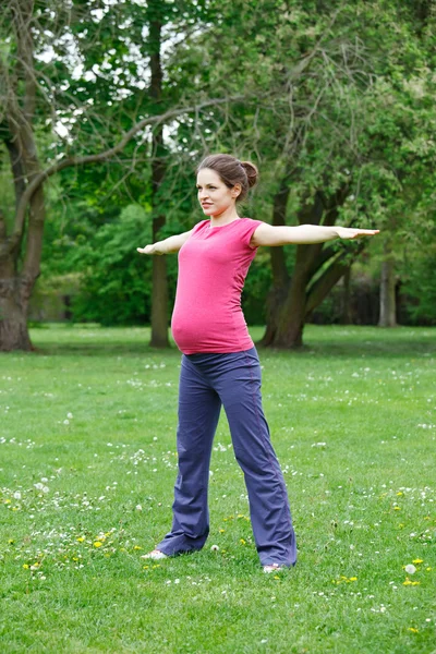 Gravid kvinna utövar i parken — Stockfoto